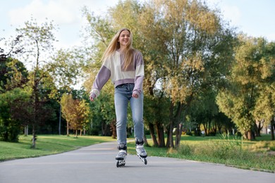 Photo of Happy young woman roller skating in park