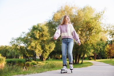 Photo of Happy young woman roller skating in park