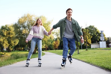 Photo of Happy couple roller skating together in park