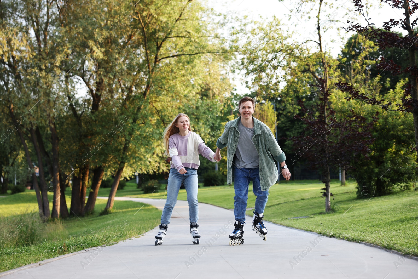 Happy couple roller skating together in park Photo of Happy couple roller skating together in park