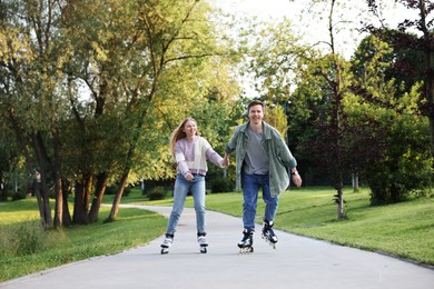 Photo of Happy couple roller skating together in park