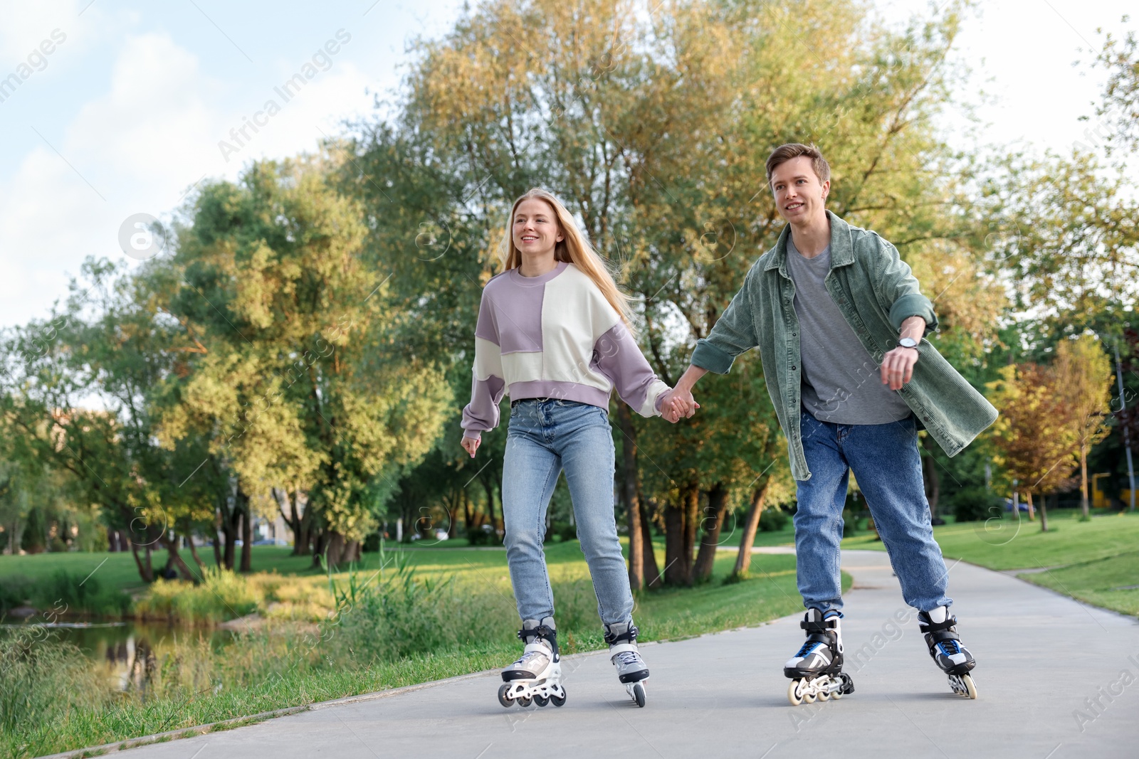 Happy couple roller skating together in park Photo of Happy couple roller skating together in park