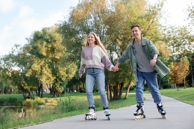 Photo of Happy couple roller skating together in park