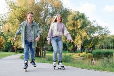 Photo of Happy couple roller skating together in park