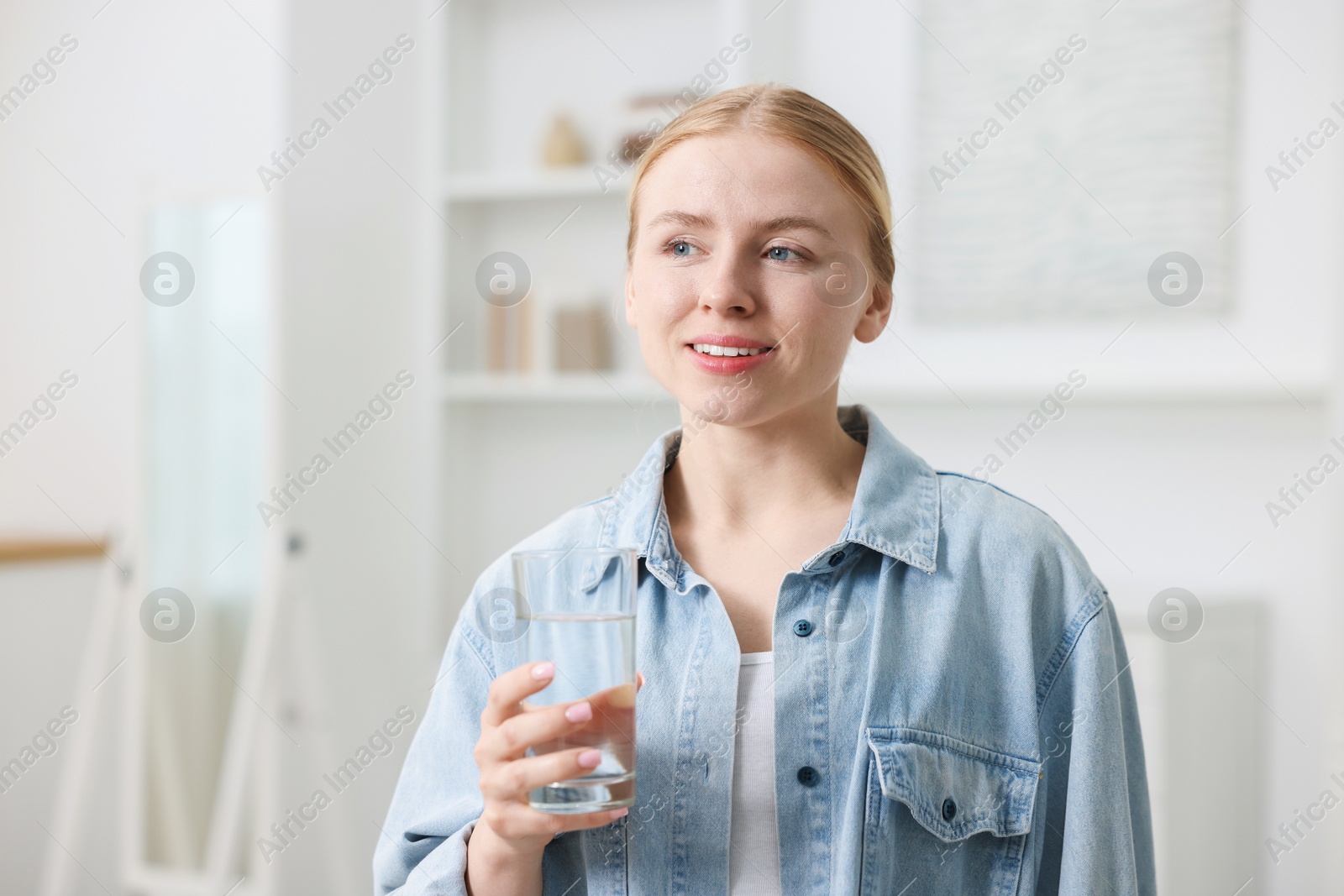 Photo of Young woman with glass of water at home