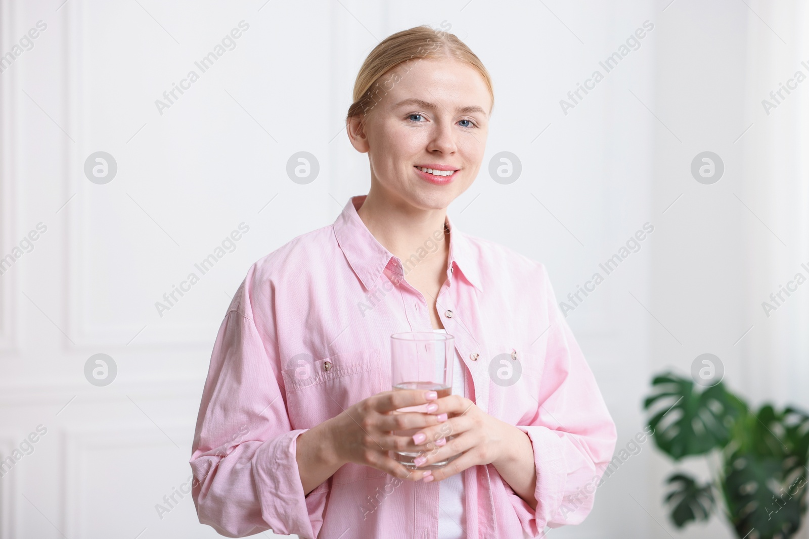 Photo of Young woman with glass of water at home