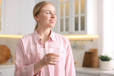 Photo of Young woman with glass of water in kitchen
