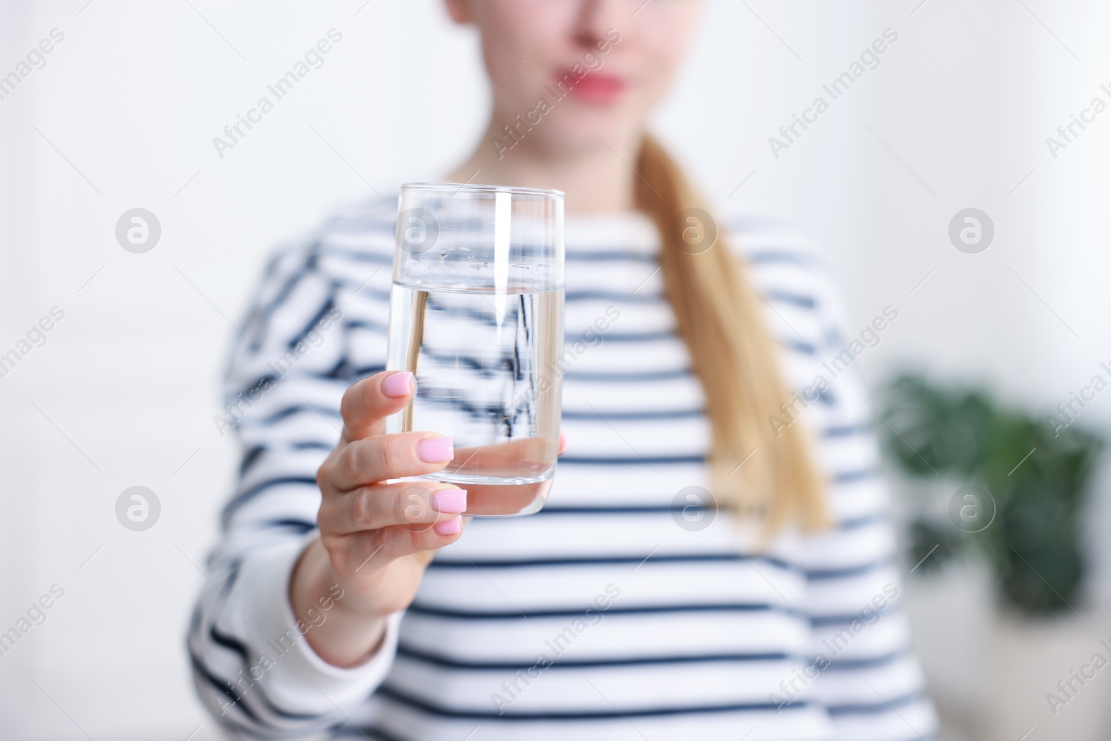 Woman with glass of water in kitchen, closeup Photo of Woman with glass of water in kitchen, closeup