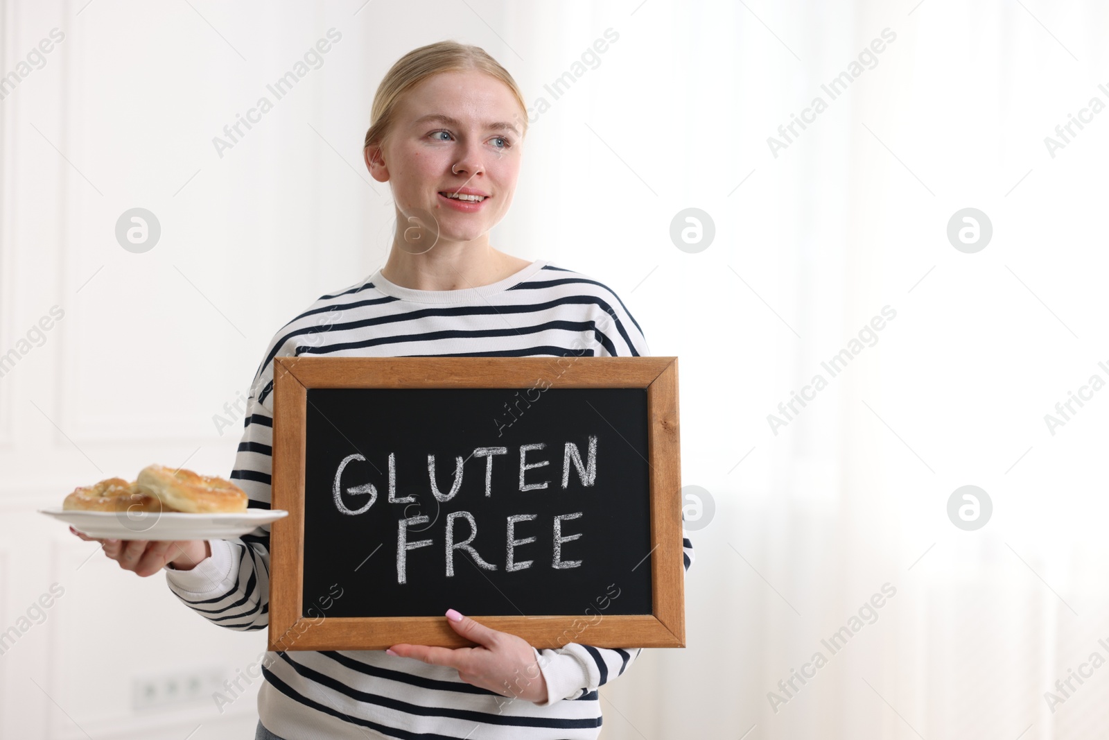 Woman holding small chalkboard with text Gluten Free and pretzels indoors. Space for text Photo of Woman holding small chalkboard with text Gluten Free and pretzels indoors. Space for text