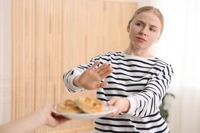 Photo of Gluten free diet. Woman refusing from pretzels indoors