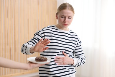 Photo of Gluten free diet. Woman refusing from donut indoors