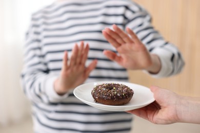Photo of Gluten free diet. Woman refusing from donut indoors, closeup