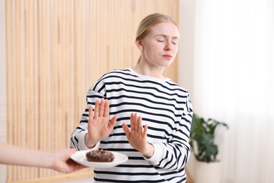 Photo of Gluten free diet. Woman refusing from donut indoors