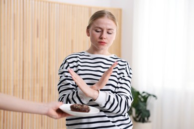 Photo of Gluten free diet. Woman refusing from donut indoors