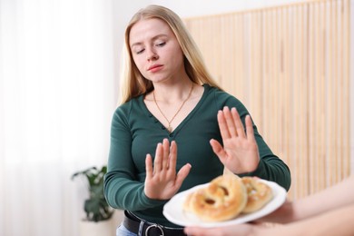 Photo of Gluten free diet. Woman refusing from pretzels indoors