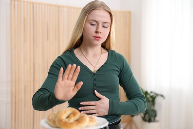 Photo of Gluten free diet. Woman refusing from pretzels indoors