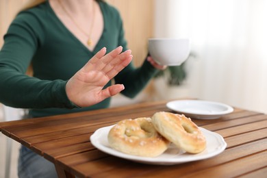 Photo of Gluten free diet. Woman refusing from pretzels indoors, closeup