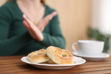 Photo of Gluten free diet. Woman refusing from pretzels indoors, selective focus