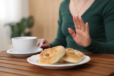 Photo of Gluten free diet. Woman refusing from pretzels indoors, closeup