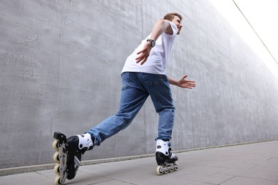 Photo of Happy young man roller skating on street, low angle view