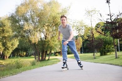 Photo of Young man roller skating in park on summer day