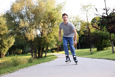 Photo of Young man roller skating in park on summer day