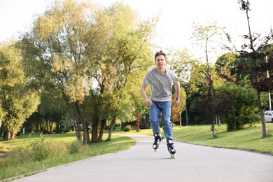 Photo of Young man roller skating in park on summer day