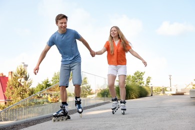 Photo of Happy couple roller skating together on street