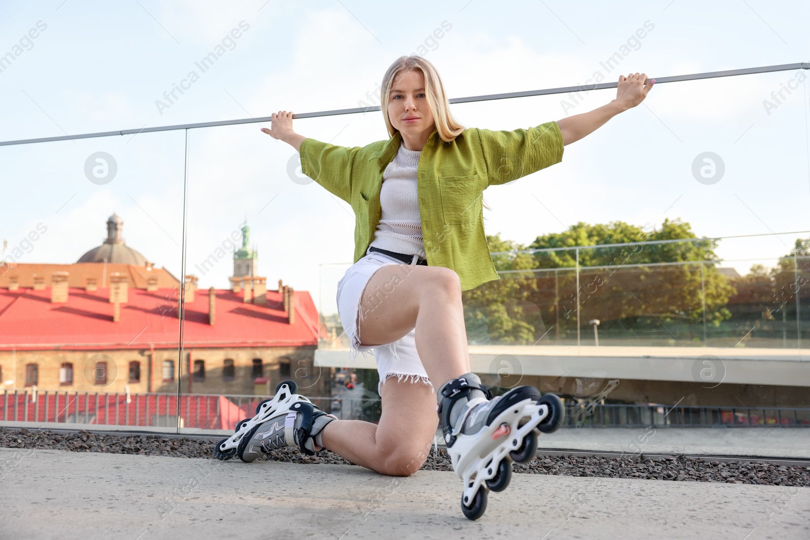 Happy woman with roller skates on street Photo of Happy woman with roller skates on street