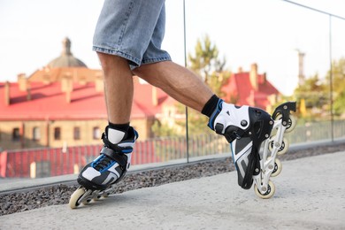 Photo of Man roller skating on city street, closeup