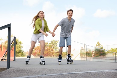 Photo of Happy couple roller skating together on street