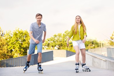 Photo of Happy couple roller skating together on street