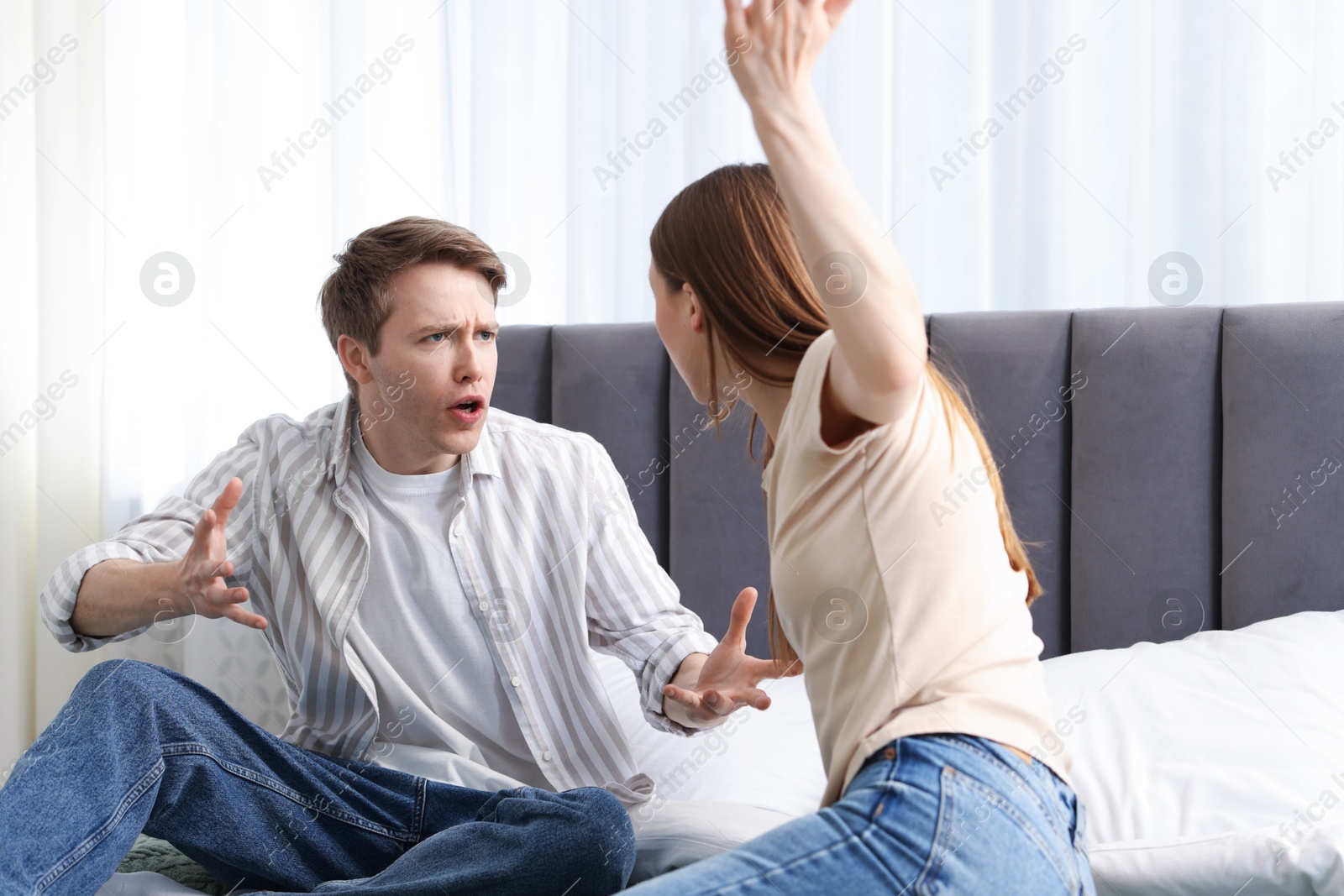 Photo of Woman and man fighting on bed at home