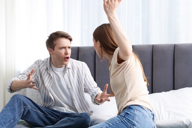 Photo of Woman and man fighting on bed at home