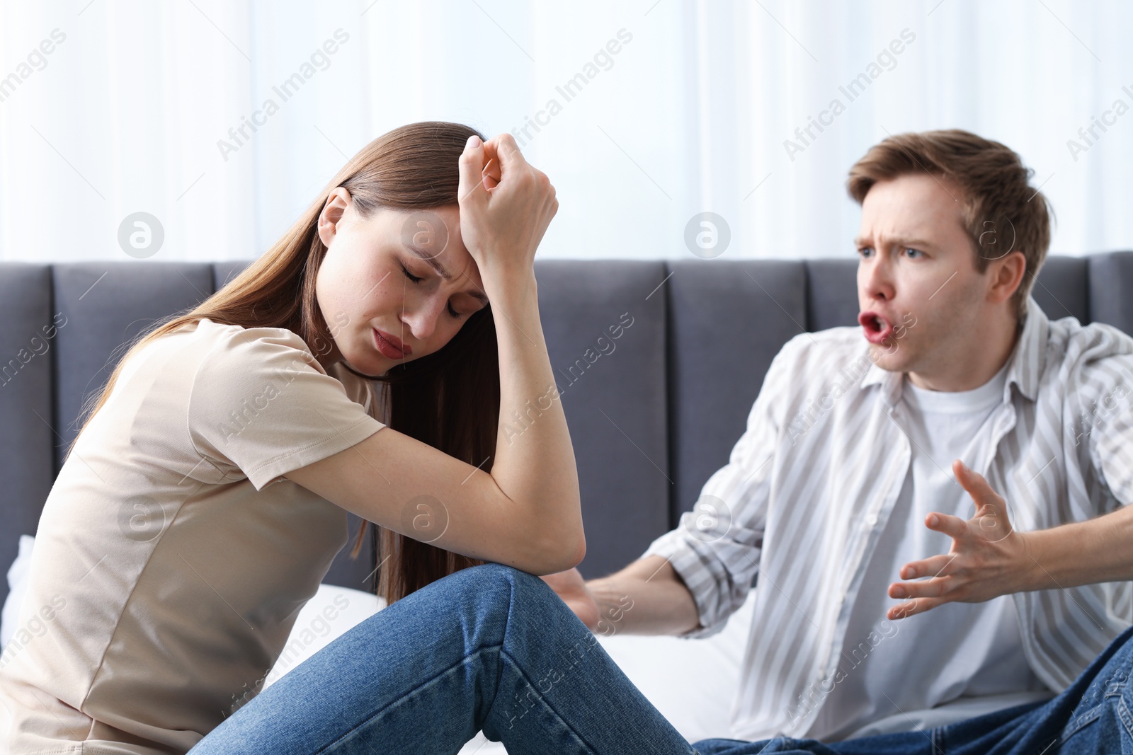 Photo of Woman and man fighting on bed at home