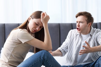 Photo of Woman and man fighting on bed at home