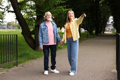 Photo of Lovely senior couple walking together in park