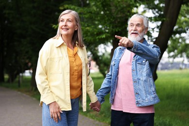 Photo of Lovely senior couple walking together in park