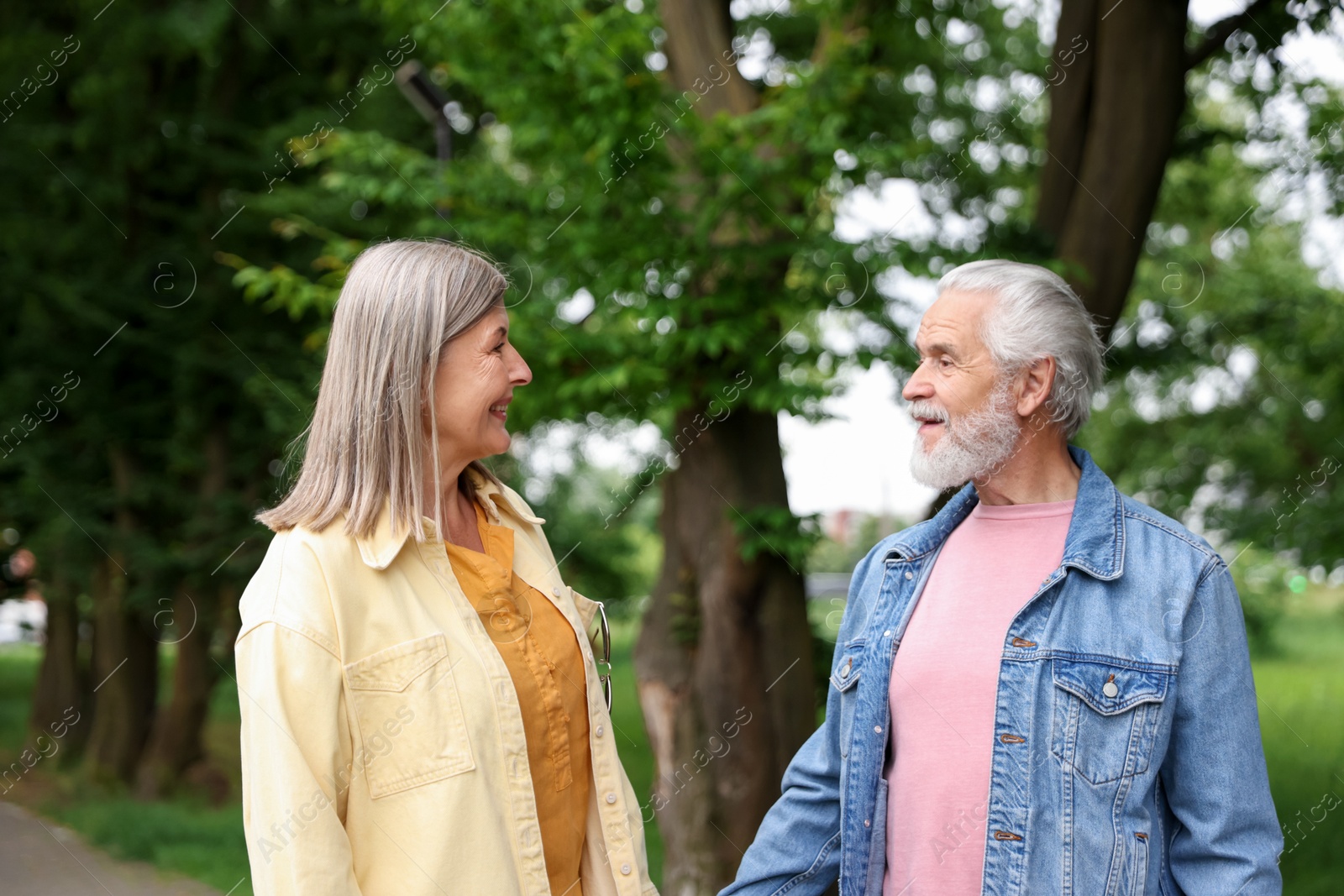 Photo of Lovely senior couple walking together in park