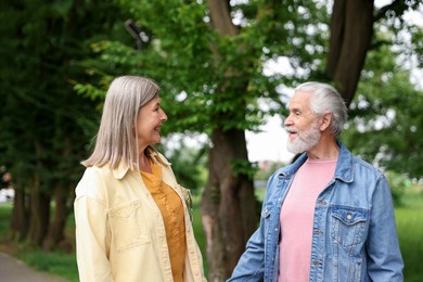 Photo of Lovely senior couple walking together in park
