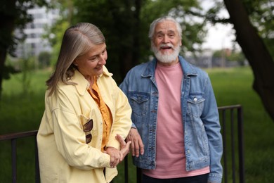 Photo of Lovely senior couple walking together in park