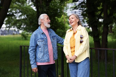Photo of Lovely senior couple walking together in park