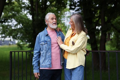 Photo of Lovely senior couple walking together in park