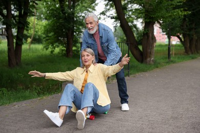Photo of Lovely senior couple having fun together in park, space for text