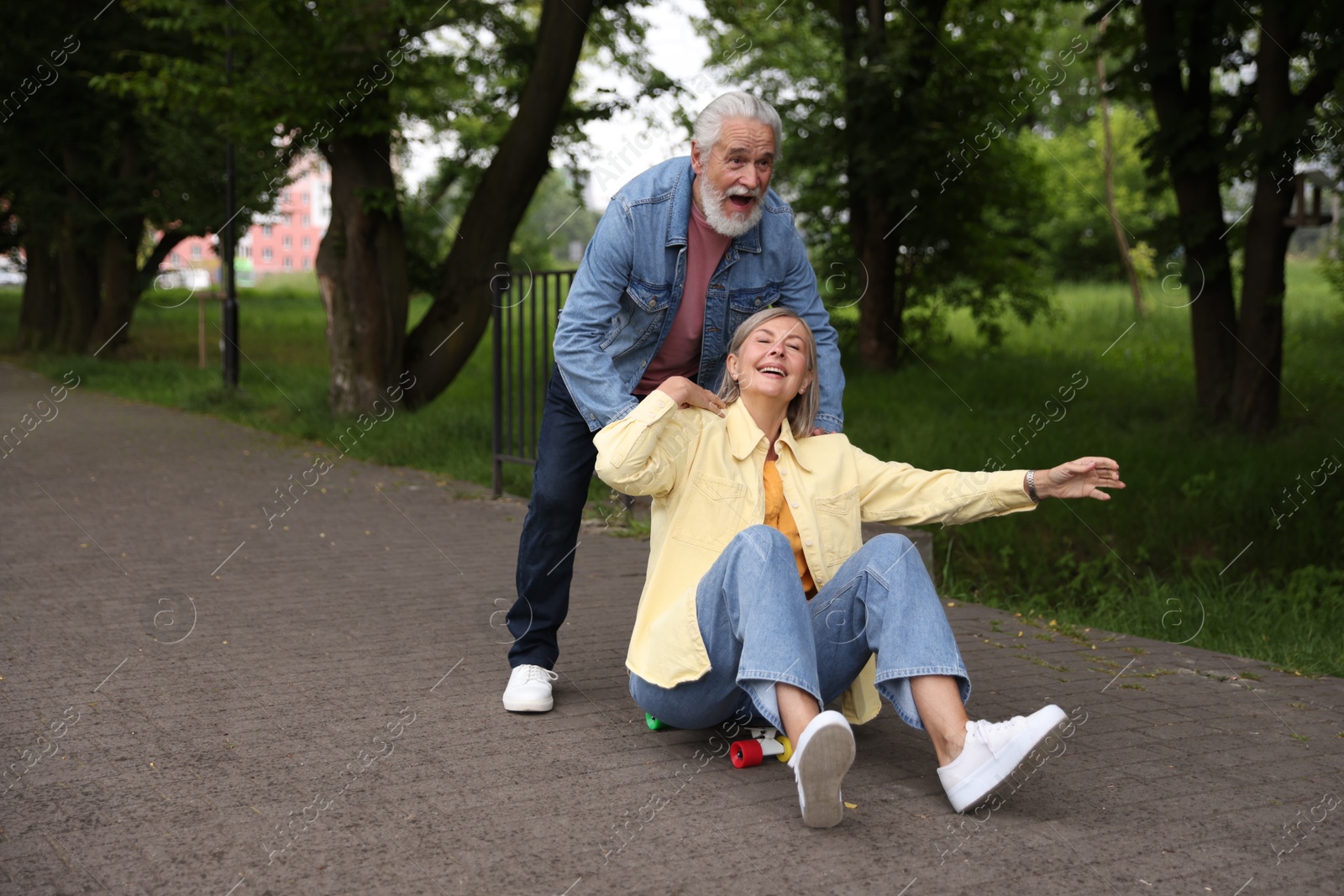 Photo of Lovely senior couple having fun together in park, space for text