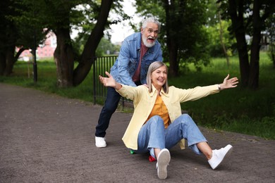 Photo of Lovely senior couple having fun together in park, space for text