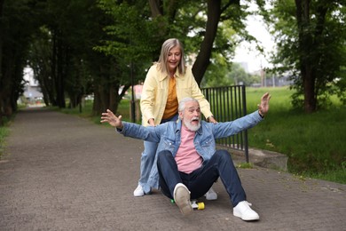 Photo of Lovely senior couple having fun together in park, space for text