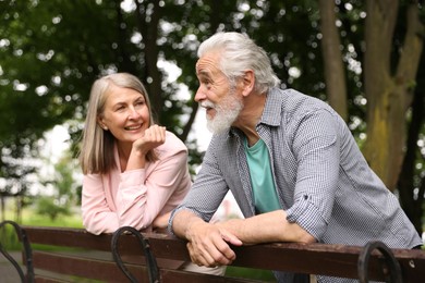 Photo of Lovely senior couple near wooden bench in park
