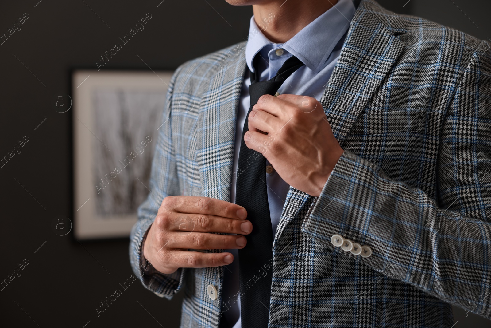 Man tying stylish necktie at home, closeup Photo of Man tying stylish necktie at home, closeup