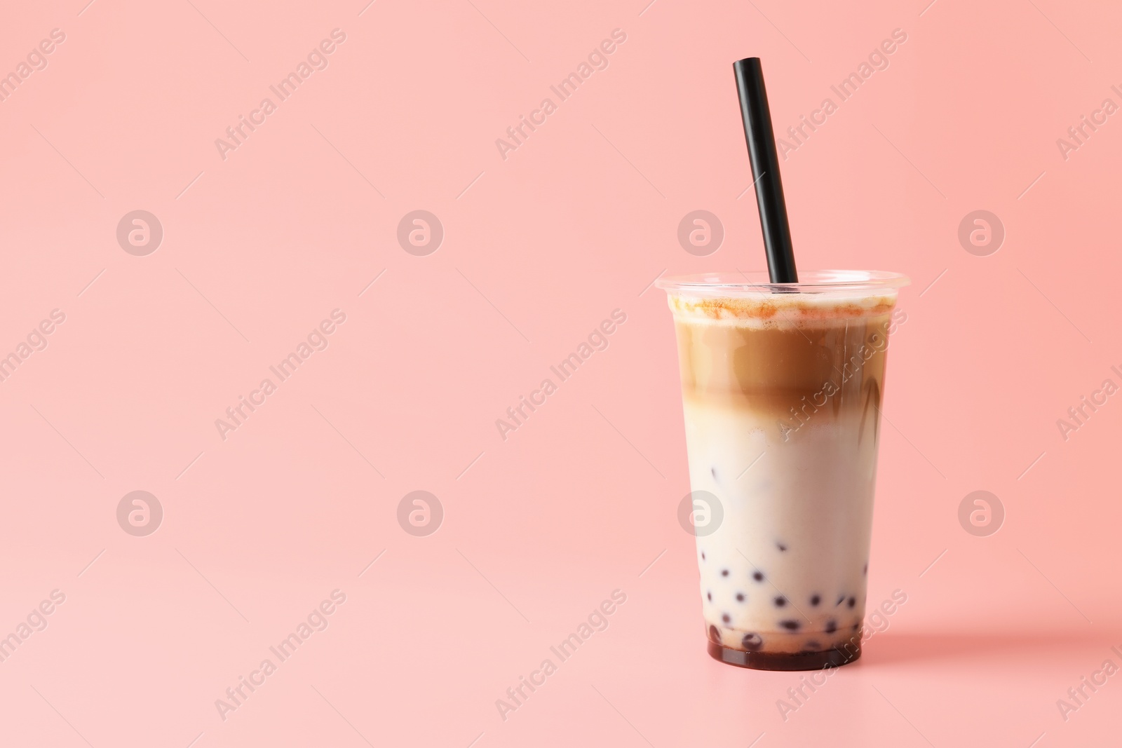Tasty milk bubble tea in plastic cup on pink background, space for text Photo of Tasty milk bubble tea in plastic cup on pink background, space for text